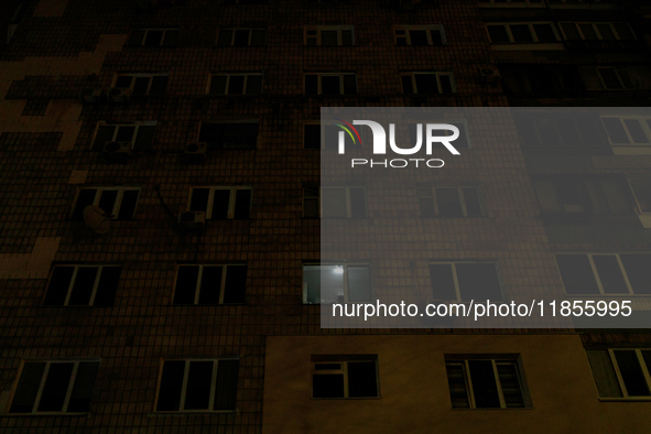 A single window in an apartment block glows in the dark in the Rusanivka neighborhood during a power cut in Kyiv, Ukraine, on December 7, 20...