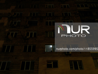 A single window in an apartment block glows in the dark in the Rusanivka neighborhood during a power cut in Kyiv, Ukraine, on December 7, 20...