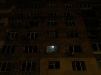 A single window in an apartment block glows in the dark in the Rusanivka neighborhood during a power cut in Kyiv, Ukraine, on December 7, 20...