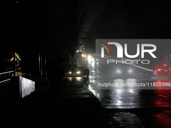 Cars move along a dark street in the Rusanivka neighborhood during a power cut in Kyiv, Ukraine, on December 7, 2024. (