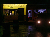 A car with headlights turned on is parked near a cafe operating during a power cut in the Rusanivka neighborhood in Kyiv, Ukraine, on Decemb...