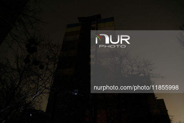 A single window in an apartment block glows in the dark in the Rusanivka neighborhood during a power cut in Kyiv, Ukraine, on December 7, 20...