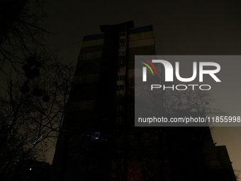 A single window in an apartment block glows in the dark in the Rusanivka neighborhood during a power cut in Kyiv, Ukraine, on December 7, 20...