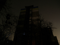 A single window in an apartment block glows in the dark in the Rusanivka neighborhood during a power cut in Kyiv, Ukraine, on December 7, 20...