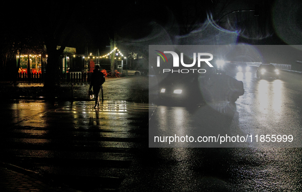 A pedestrian crosses a dark street in the Rusanivka neighborhood during a power cut in Kyiv, Ukraine, on December 7, 2024. NO USE RUSSIA. NO...