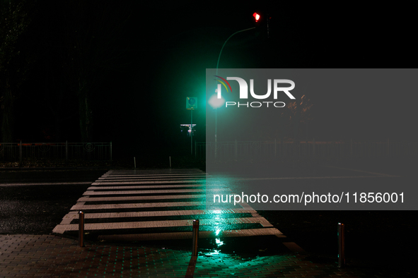 A traffic light turns green at a zebra crossing in the dark in the Rusanivka neighborhood during a power cut in Kyiv, Ukraine, on December 7...