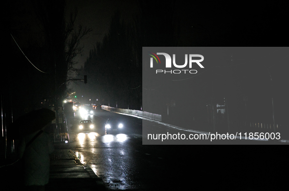 Cars move along a dark street in the Rusanivka neighborhood during a power cut in Kyiv, Ukraine, on December 7, 2024. 