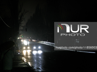 Cars move along a dark street in the Rusanivka neighborhood during a power cut in Kyiv, Ukraine, on December 7, 2024. (