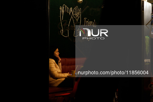 A woman works in a cafe during a power cut in the Rusanivka neighborhood in Kyiv, Ukraine, on December 7, 2024. NO USE RUSSIA. NO USE BELARU...