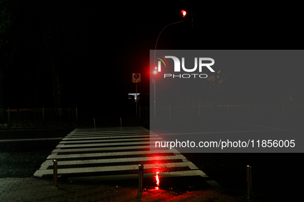 A traffic light turns red at a zebra crossing in the dark in the Rusanivka neighborhood during a power cut in Kyiv, Ukraine, on December 7,...