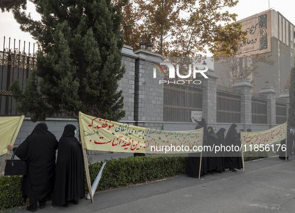 Veiled Iranian women hold placards while participating in a rally to support the Hijab bill outside the Iranian Parliament building in Tehra...