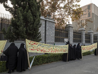 Veiled Iranian women hold placards while participating in a rally to support the Hijab bill outside the Iranian Parliament building in Tehra...