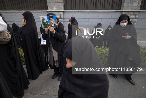 A veiled Iranian woman holds portraits of Lebanon's Hezbollah leader, Hassan Nasrallah, and an Iranian warrior while participating in a rall...