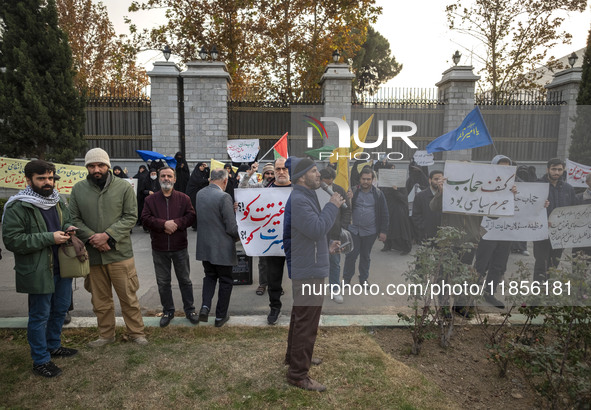 A small group of Iranian men holds placards while participating in a rally to support the Hijab bill outside the Iranian Parliament building...