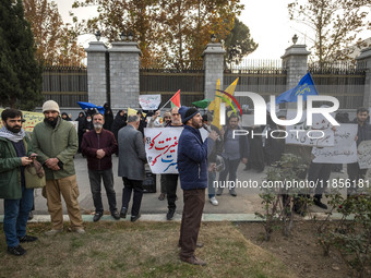 A small group of Iranian men holds placards while participating in a rally to support the Hijab bill outside the Iranian Parliament building...