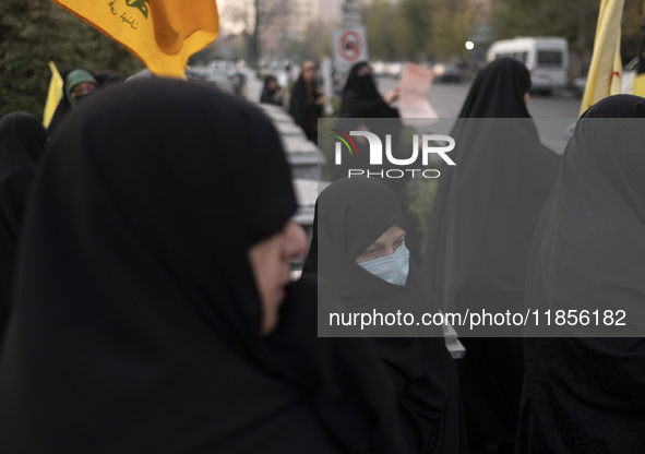 A veiled Iranian woman wears a protective face mask and looks on while participating in a rally to support the Hijab bill outside the Irania...