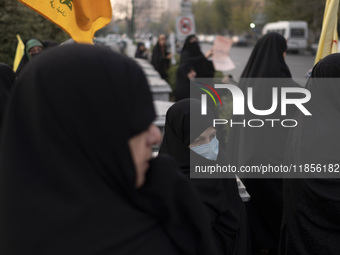 A veiled Iranian woman wears a protective face mask and looks on while participating in a rally to support the Hijab bill outside the Irania...