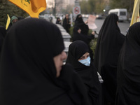 A veiled Iranian woman wears a protective face mask and looks on while participating in a rally to support the Hijab bill outside the Irania...