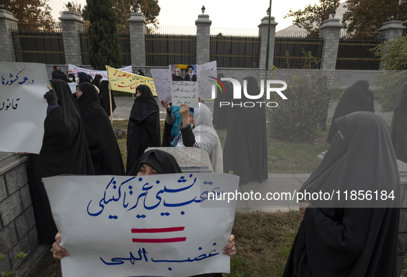 A veiled Iranian woman holds a placard with Persian script that reads, ''Non-tactical retreat equals divine wrath,'' during a rally to suppo...