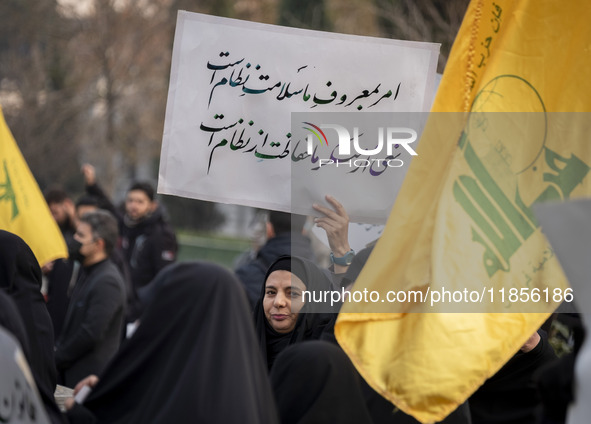 A veiled Iranian woman holds up a placard with Persian script that reads, ''Our command to do good is the health of the regime, our prohibit...