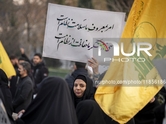 A veiled Iranian woman holds up a placard with Persian script that reads, ''Our command to do good is the health of the regime, our prohibit...