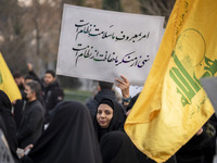 A veiled Iranian woman holds up a placard with Persian script that reads, ''Our command to do good is the health of the regime, our prohibit...