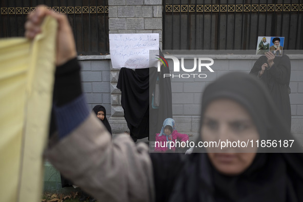 A veiled Iranian woman holds portraits of Lebanon's Hezbollah late leader, Hassan Nasrallah, and an Iranian warrior while participating in a...