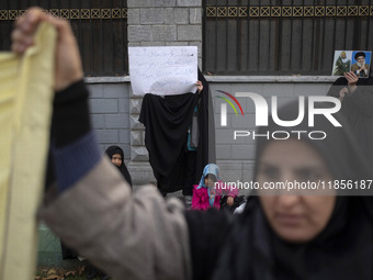 A veiled Iranian woman holds portraits of Lebanon's Hezbollah late leader, Hassan Nasrallah, and an Iranian warrior while participating in a...