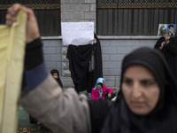 A veiled Iranian woman holds portraits of Lebanon's Hezbollah late leader, Hassan Nasrallah, and an Iranian warrior while participating in a...