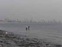 A boy takes a mobile photo of a girl near a sea beach in Mumbai, India, on December 11, 2024. (