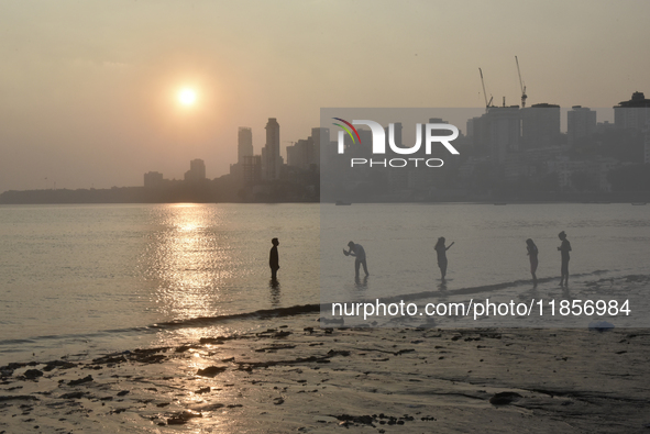 A boy takes a mobile photograph near a sea beach in Mumbai, India, on December 11, 2024. 