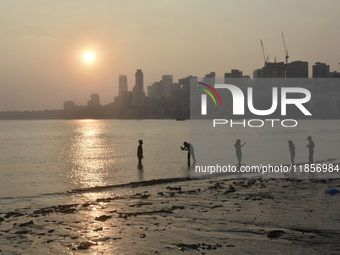 A boy takes a mobile photograph near a sea beach in Mumbai, India, on December 11, 2024. (