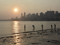 A boy takes a mobile photograph near a sea beach in Mumbai, India, on December 11, 2024. (