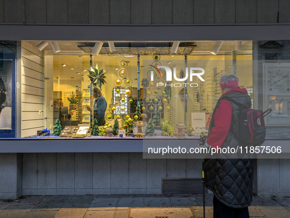 An elderly woman admires the festive Christmas window display in Munich, Bavaria, Germany, on December 11, 2024. The window features a Chris...