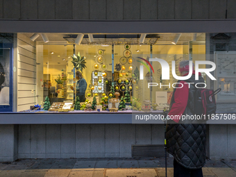 An elderly woman admires the festive Christmas window display in Munich, Bavaria, Germany, on December 11, 2024. The window features a Chris...