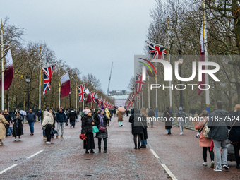 People walk along The Mall, decorated with Union Jack flags, in London, United Kingdom, on December 7, 2024 (