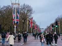 People walk along The Mall under festive Union Jack flags, in London, United Kingdom, on December 7, 2024. (