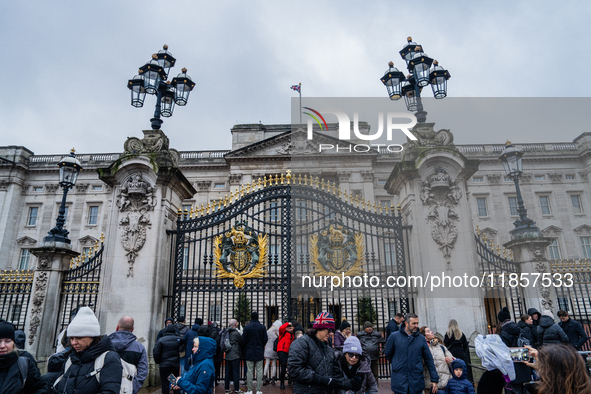 Visitors gather outside the gates of Buckingham Palace, in London, United Kingdom, on December 7, 2024. 