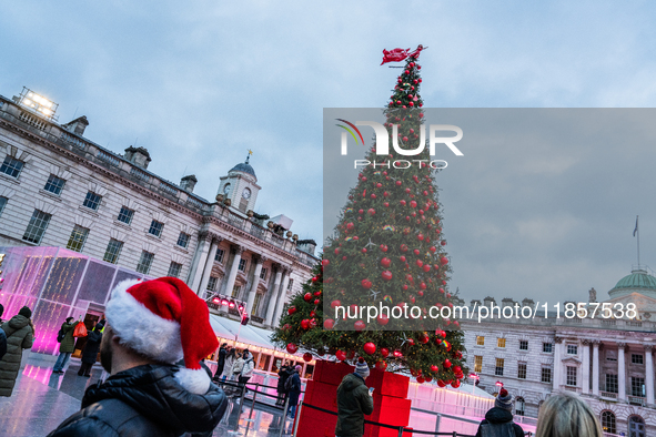 People admire the Christmas tree at Somerset House, in London, United Kingdom, on December 7, 2024 