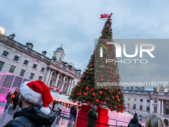 People admire the Christmas tree at Somerset House, in London, United Kingdom, on December 7, 2024 (