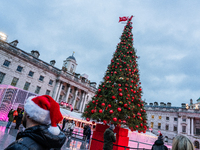 People admire the Christmas tree at Somerset House, in London, United Kingdom, on December 7, 2024 (