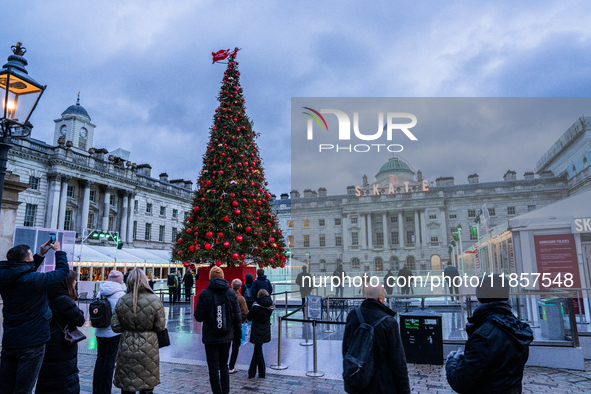 People admire the Christmas tree at Somerset House, in London, United Kingdom, on December 7, 2024 