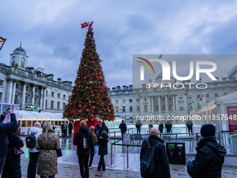 People admire the Christmas tree at Somerset House, in London, United Kingdom, on December 7, 2024 (