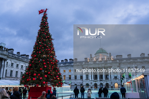 People admire the Christmas tree at Somerset House, in London, United Kingdom, on December 7, 2024 