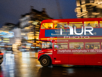 A red double-decker bus travels through the streets of London, United Kingdom, on December 7, 2024 (