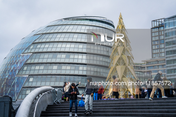 Visitors admire a modern Christmas tree installation near City Hall, in London, United Kingdom, on December 8, 2024 