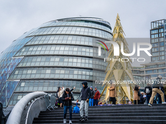 Visitors admire a modern Christmas tree installation near City Hall, in London, United Kingdom, on December 8, 2024 (