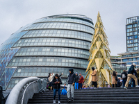 Visitors admire a modern Christmas tree installation near City Hall, in London, United Kingdom, on December 8, 2024 (