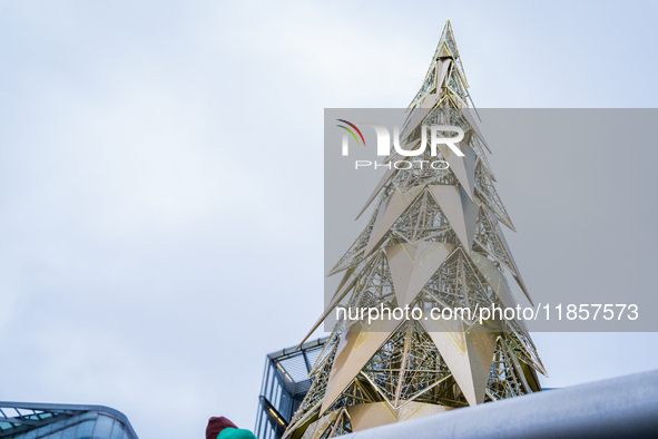 Visitors admire a modern Christmas tree installation near City Hall, in London, United Kingdom, on December 8, 2024 