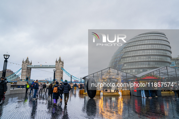 People explore the Christmas market near Tower Bridge and City Hall, in London, United Kingdom, on December 8, 2024 